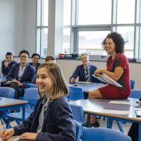 pupils and teacher smiling in class