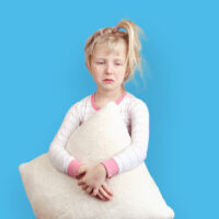 young girl with pillow standing cant sleep