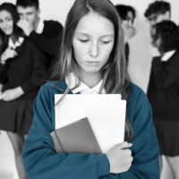 Bullied teen school girl having classmates luagh behind her back