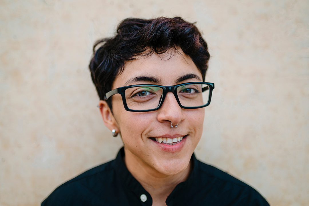 Close up view of a young transgender man looking at camera and smiling.