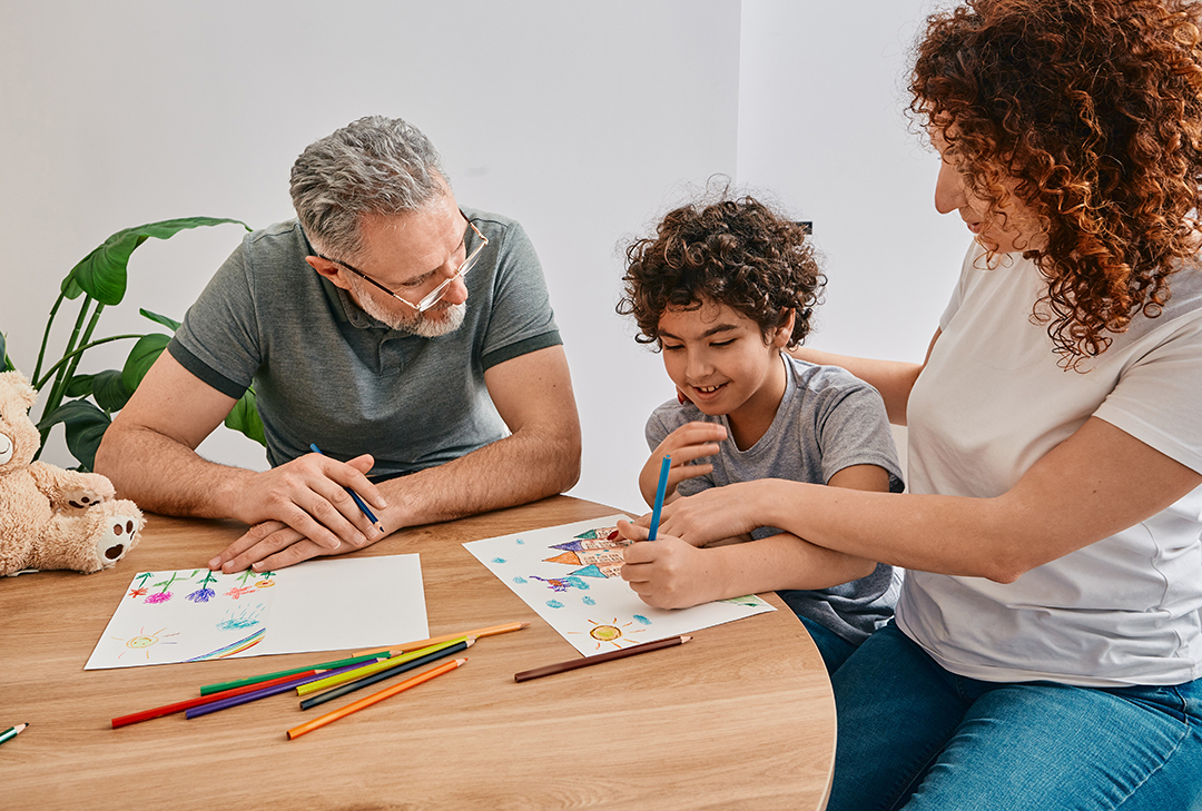 Psychologist doing art therapy for curly boy patient during psychologist visit. Children mental health