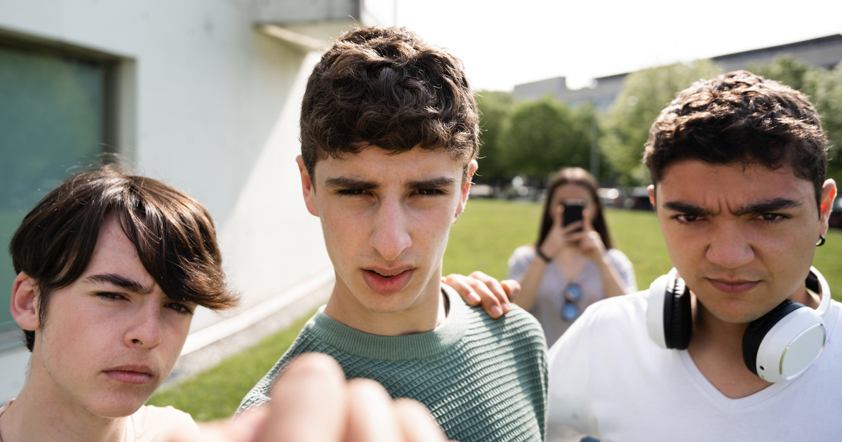 Bullied person view of aggressive friends menacing. Bullying and violence on teenagers concept