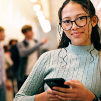 teen girl in school on mobile