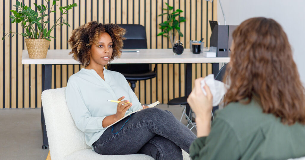African American female psychologist conducts an appointment with a patient in the office. mental health and moral support. woman is a patient with mental difficulties and a mental disorder