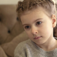 Portrait of little girl aged . Moody and confused girl. Mistreated child.