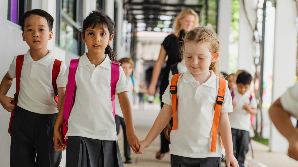 Primary School Students Wearing Uniform walking in outdoor hallway going to class Primary School Students Wearing Uniform walking in outdoor hallway going to class