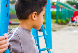 dark haired boy swinging on a swing