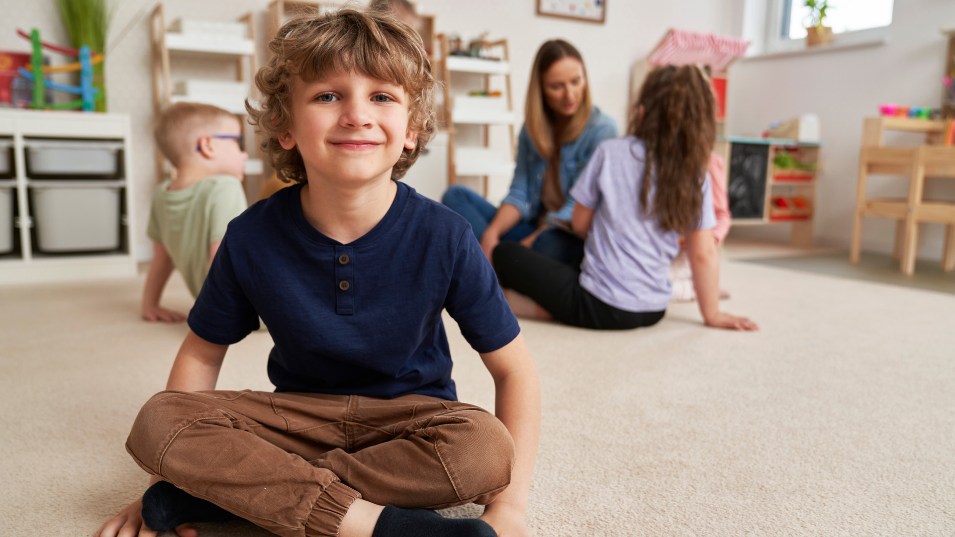 Portrait of preschool boy and children in the background