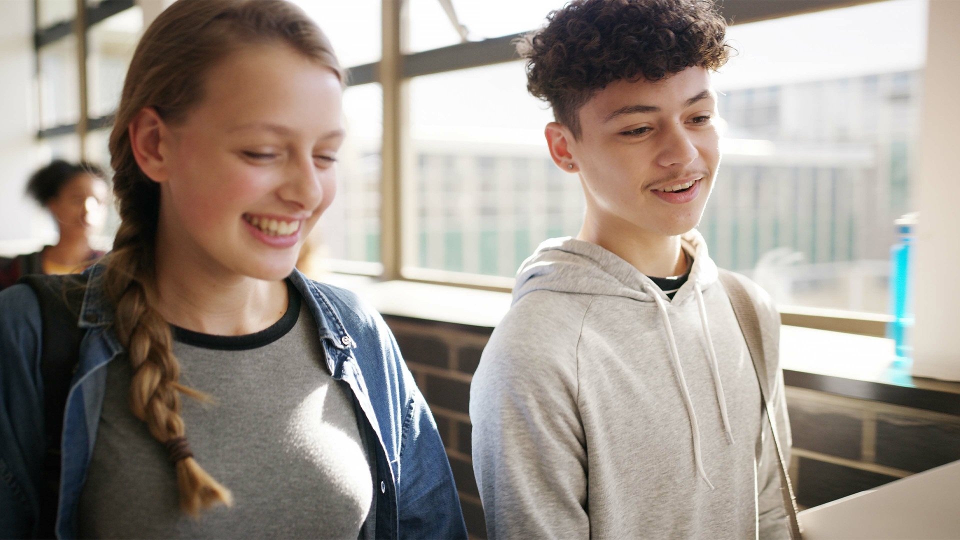 Boy, girl and laugh in hallway with books