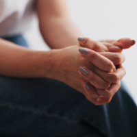 Woman with her hands together during trauma informed practice training